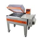 Clamco Dempack H30 One-Step Shrink Wrap System featuring a transparent sealing hood, control panel with digital display, and integrated film roll holder on a wheeled metal frame.