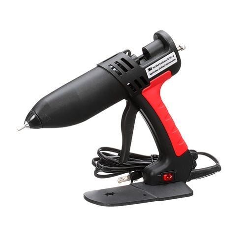 A black and red 3M™ Poly Gun LT Glue Applicator with a cord and switch, resting on its stand, designed for precision hot glue application.