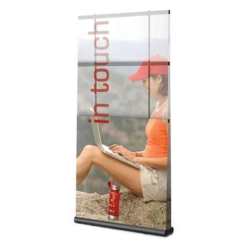 Black Retractable Single-Sided Banner Stand (36" Wide x Up to 96" High) displaying a vertical banner with a woman using a laptop outdoors and the text 'in touch' on the graphic.