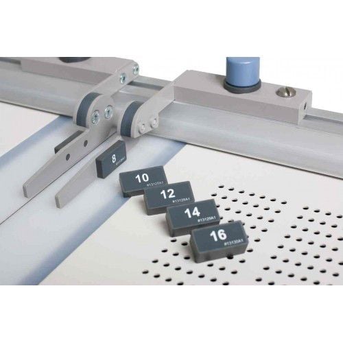 Close-up of a binding machine with Fastbind Quick Change Spine Spacers labeled 8, 10, 12, 14, and 16 lined up on a perforated surface.