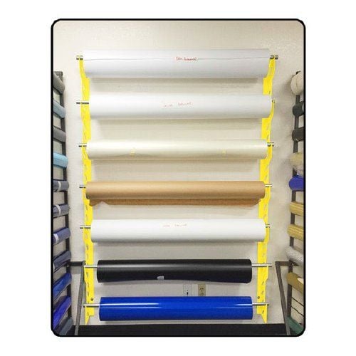 A Mondo Raxx Jumbo Mountable Banner Material Storage rack holding multiple rolls of banner material in various colors.