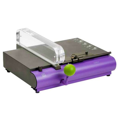 A Fastback Scoring/Creasing Machine featuring a compact, modern design with a purple base and green handle, used for precise scoring and creasing of paper and other materials.