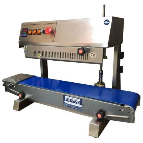 The SealerSales FR-770II Vertical Continuous Band Sealer (Left Feed) features a stainless steel construction with a control panel, bright blue conveyor belt, and a sealing mechanism for continuous operation.