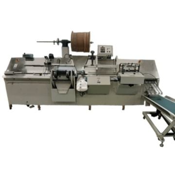 James Burn BB420 In-Line Split Punch - Wire Binder Closer, featuring a complex setup with a conveyor belt, wire spool, and various mechanical components designed for precise punching and wire binding tasks in a high-volume production environment.