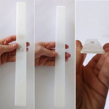 A hand holds a white rectangular replacement part for "Punch Pads for FP-1XLS Manual Paper Hole Drill," shown from three angles to display its flat surface, thickness, and central alignment feature.