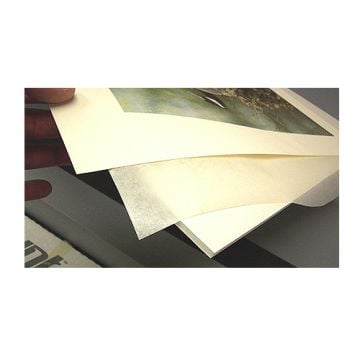 A close-up image showing several layers of Dry Mount Release Paper being separated, used to protect artwork during the dry mounting process.