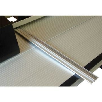 A close-up view of the Rotatrim 36" Rule Extension Kit for Technical, DigiTech+ and PowerTech Trimmers, showing the metallic guide rail positioned on a gridded cutting surface.