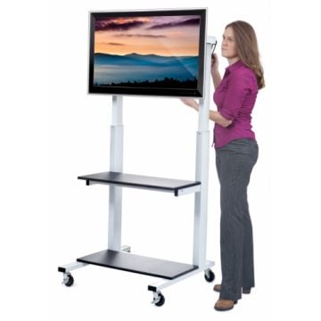 A woman adjusts the height of a mounted screen on a Luxor Crank Adjustable Flat Panel LCD TV Cart, featuring a sturdy metal frame with shelves and rolling casters.
