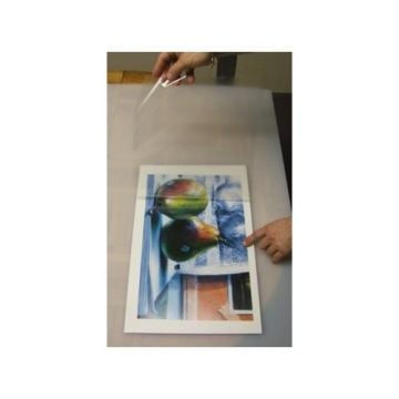 A person is holding a clear sheet above a print mounted on Polar Pressure Sensitive Gator Pouch Boards - Gloss White.