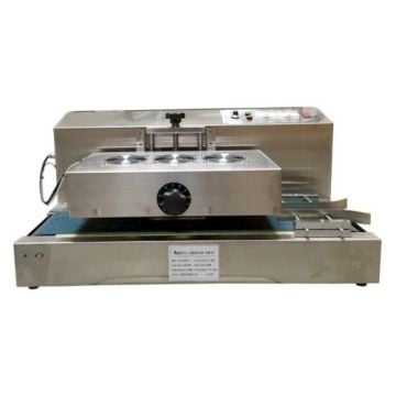 A stainless steel SealerSales Table-Style Continuous Induction Sealer with a conveyor belt system, cooling fans on top, and control buttons on the side, designed for sealing operations in industrial settings.