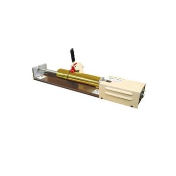 A manual Therm-O-Type Foil Cutter with a compact design, featuring a golden cutting cylinder, a lever handle, and a sturdy metallic base.