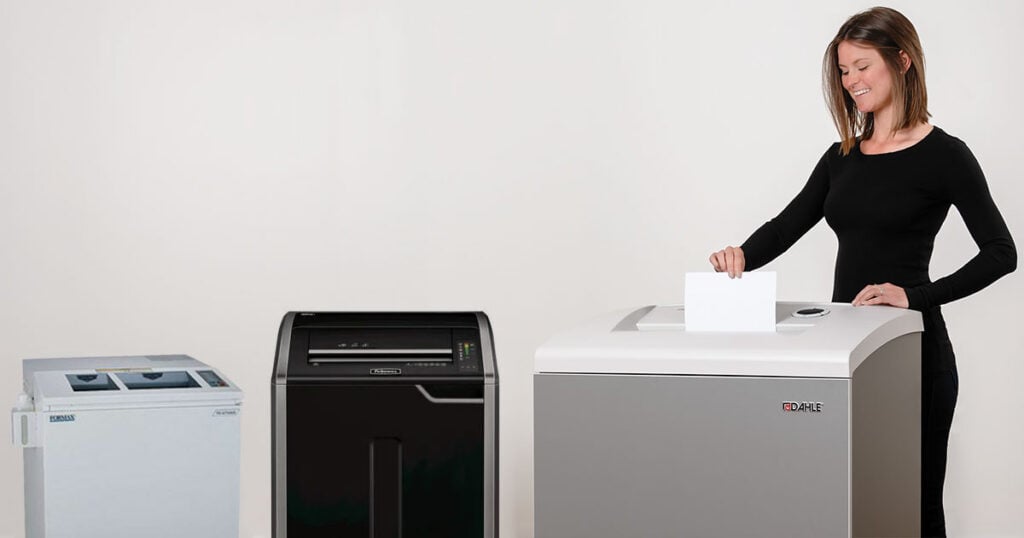 Female government employee shredding paper in a Dahle machine. 