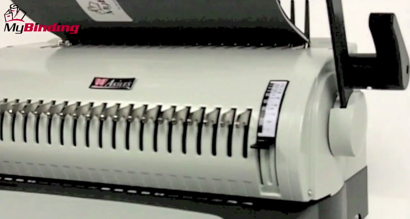 A binding cover face down moving through the comb machine